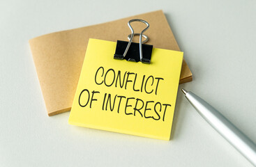 Conflict of Interest text on blank business card being held by a woman's hand with blurred...