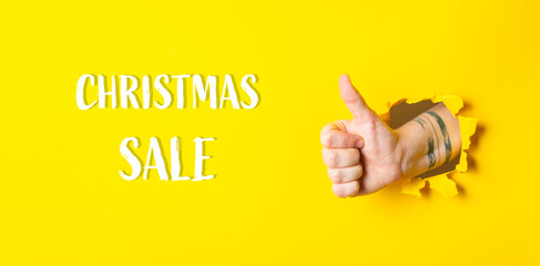 A hand giving a thumbs up with the words Christmas Sale written below it