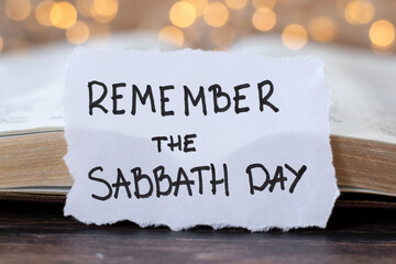 Remember the Sabbath Day, handwritten quote with holy bible book and bokeh light background....