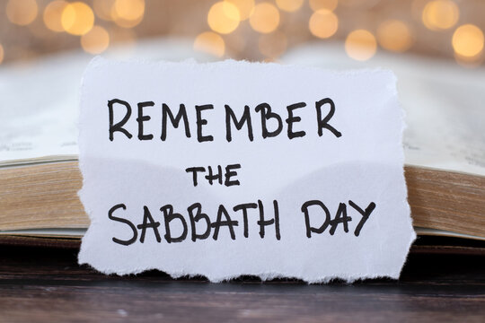 Remember the Sabbath Day, handwritten quote with holy bible book and bokeh light background. Closeup. Christian blessing, rest and obedience to God Jesus Christ, biblical concept.
