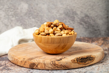 Mixed nuts on wooden background. Nuts in a bowl