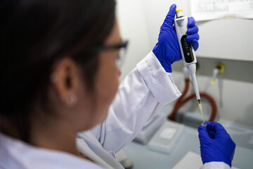 a scientist extracting a liquid sample