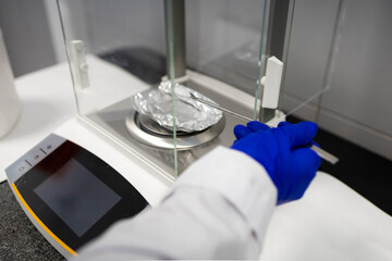 scientist weighing a sample on a scale
