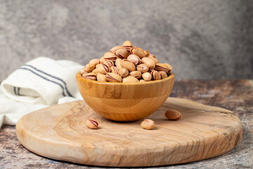 Pile of pistachios on wooden background. Pistacia vera
