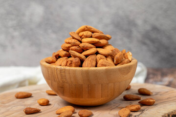 Almonds on wood background. Roasted almonds in a bowl. Close up