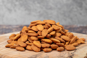 Pile of almonds on wood background. Close up
