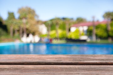 Empty blank wooden table at swimming pool background