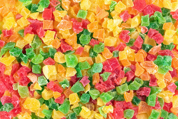 Candied colorful fruits bits. Confectionery background, sweet dried pineapples, oranges and papayas in sugar syrup, Flat lay