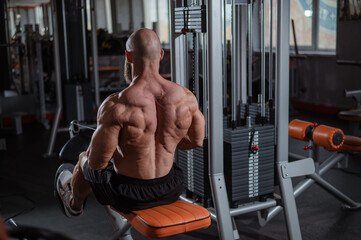 Naklejka premium Caucasian man doing rowing exercises on a rowing machine. 