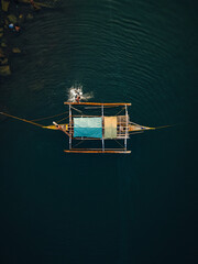 a Philippine boat anchored and children swimming in the water