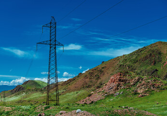 Obraz premium Electric power line in high mountains in summer