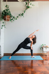 latin girl practicing side angle yoga posture. Copy space.