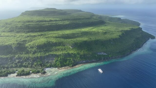 A diving liveaboard ship anchors off the coast of a remote island, Pulau Damar, in the Tanimbar Islands of Indonesia. This tropical area harbors beautiful coral reefs and a wide diversity of fishes.