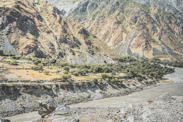The Panj River flows in the valley Along the Pamir Highway in the mountains of Tajikistan in the morning, a noisy powerful river flows among the rocks