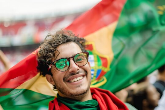 Portuguese football fan smiling and cheering with national flag