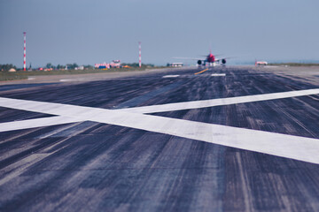 A white cross on an airport runway prohibits landing of airliners due to repairs. Close-up view of...