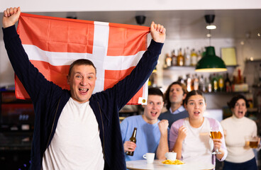 Fototapeta premium Danish fans scream with joy in a beer bar. Denmark win