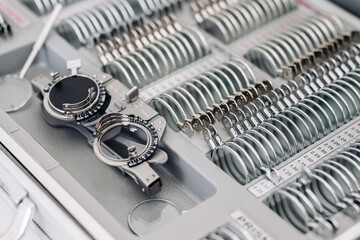 Test frame isolated at the ophthalmologist's workplace in a modern clinic. Ophthalmologist instrument, trial glasses for vision testing and lenses.