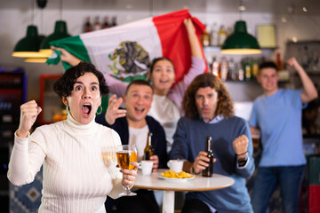 Joyful fans of the Mexican team celebrating the victory in the night bar