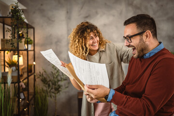 Happy couple read the good news in the post envelope letter at home