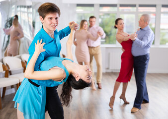 Teaching latin american dances in a dance studio - people of different ages dance in pairs