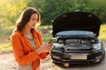 Sad woman has broken down car on roadside, feeling stressed, calling and searching for help....