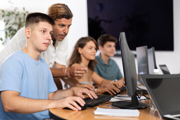 Fototapeta premium Student and teacher collaborate on research project using their computers.