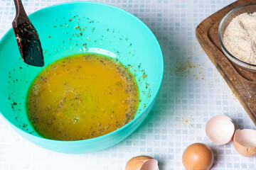 Egg beaten with garlic and parsley for pork breading.