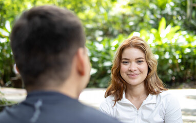 Fototapeta premium beautiful woman in sportswear sitting talking in a park while looking at the camera