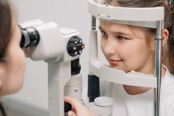 Examination of the child using a slit lamp. Microscope and focused light source. A device for high-precision examination of the eye to determine the condition of the lens.