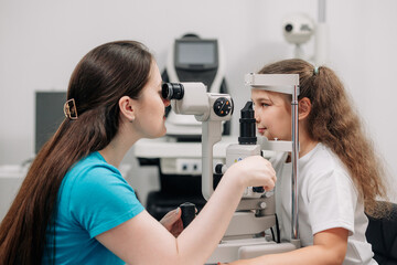 Examination of the child using a slit lamp. Microscope and focused light source. A device for high-precision examination of the eye to determine the condition of the lens.