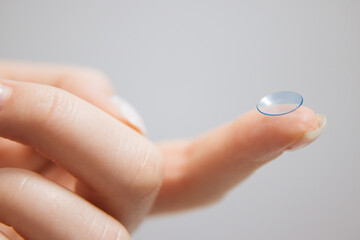 Concept of vision correction and maintenance. Close-up of a contact lens on a light background.