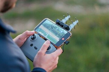 Close-Up of Hands Operating FPV Drone Remote Controller with Smartphone Display