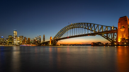 Fototapeta premium Long exposure of the amazing Sydney Harbour Bridge and Sydney's Downtown from the north bank namely Mattawunga at sunset