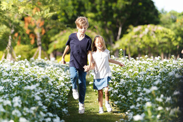 Obraz premium Caucasian white siblings playing at the park in morning.