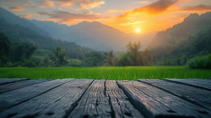 Fototapeta premium A serene sunset illuminating green fields and distant mountains, viewed from a rustic wooden deck, creating a picturesque landscape.