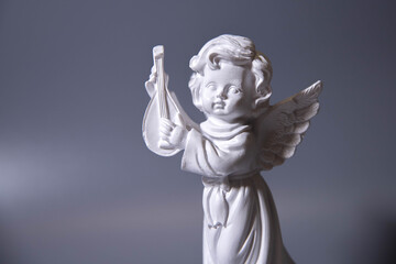 Angel figure with musical instrument on cloud