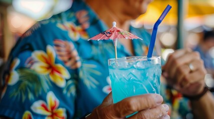 A closeup of a Hawaiian shirtclad customer taking a sip of a bright blue drink complete with a tiny umbrella on top.