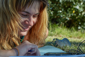 Student studying language notes in park