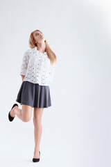 Young woman looking up with hands behind back