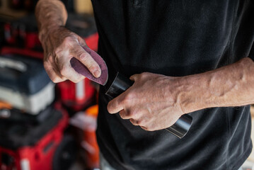 Plumber's hands using sandpaper on PVC pipe