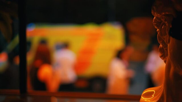 In a slow motion sequence, indistinct faces and emergency vehicles move through a chaotic urban setting at night