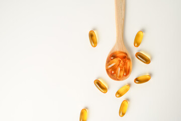wooden spoon with soft gels, Fish oil capsules, omega 3, omega 9, vitamin D, vitamin E