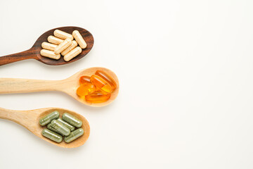 Vitamin capsules in a wooden spoon, soft gels, Fish oil capsules, omega 3, omega 9, vitamin D,...