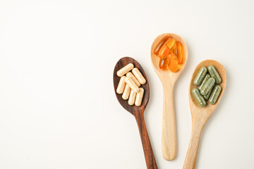 Vitamin capsules in a wooden spoon, soft gels, Fish oil capsules, omega 3, omega 9, vitamin D, vitamin E