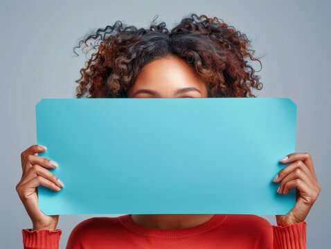 A person is holding a large blank blue board, which provides space for text or graphic additions