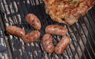Top view of pork sausages, chorizos, roasting in the grill outdoor