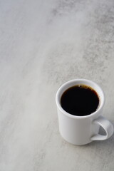 朝のひと時、お気に入りのマグカップに淹れたてのコーヒーを入れてひと休みしているイメージ
