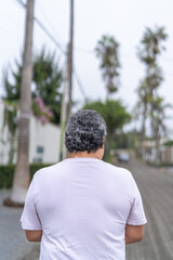 Rear view of a man with vitiligo in the street