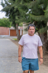Man with vitiligo walking along a rural street